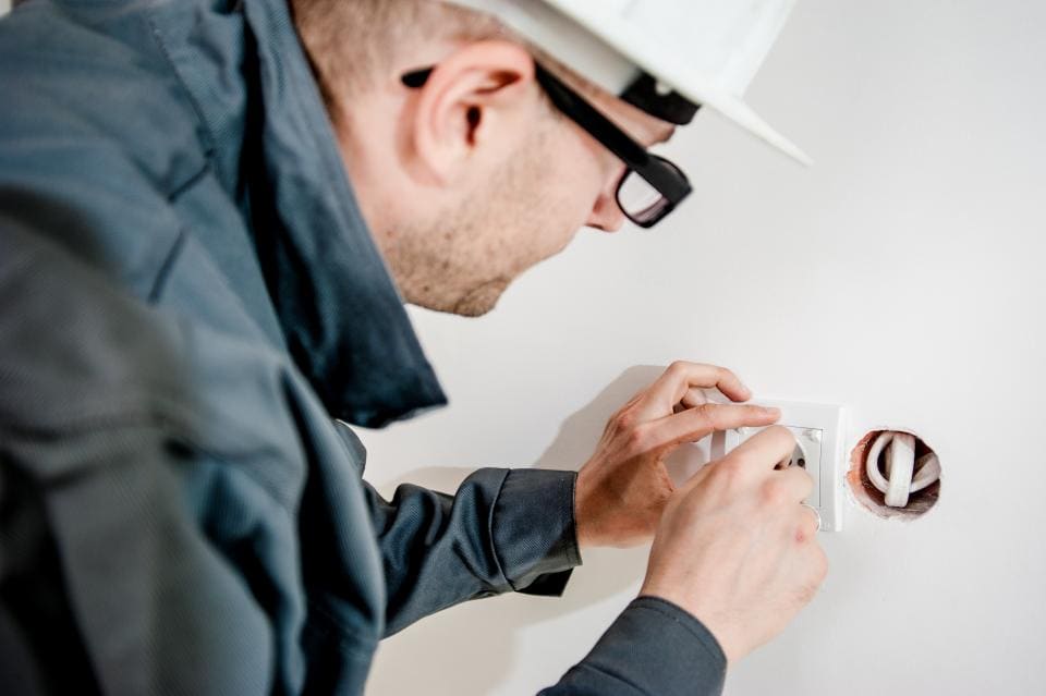 Electrician installing a new outlet in a home