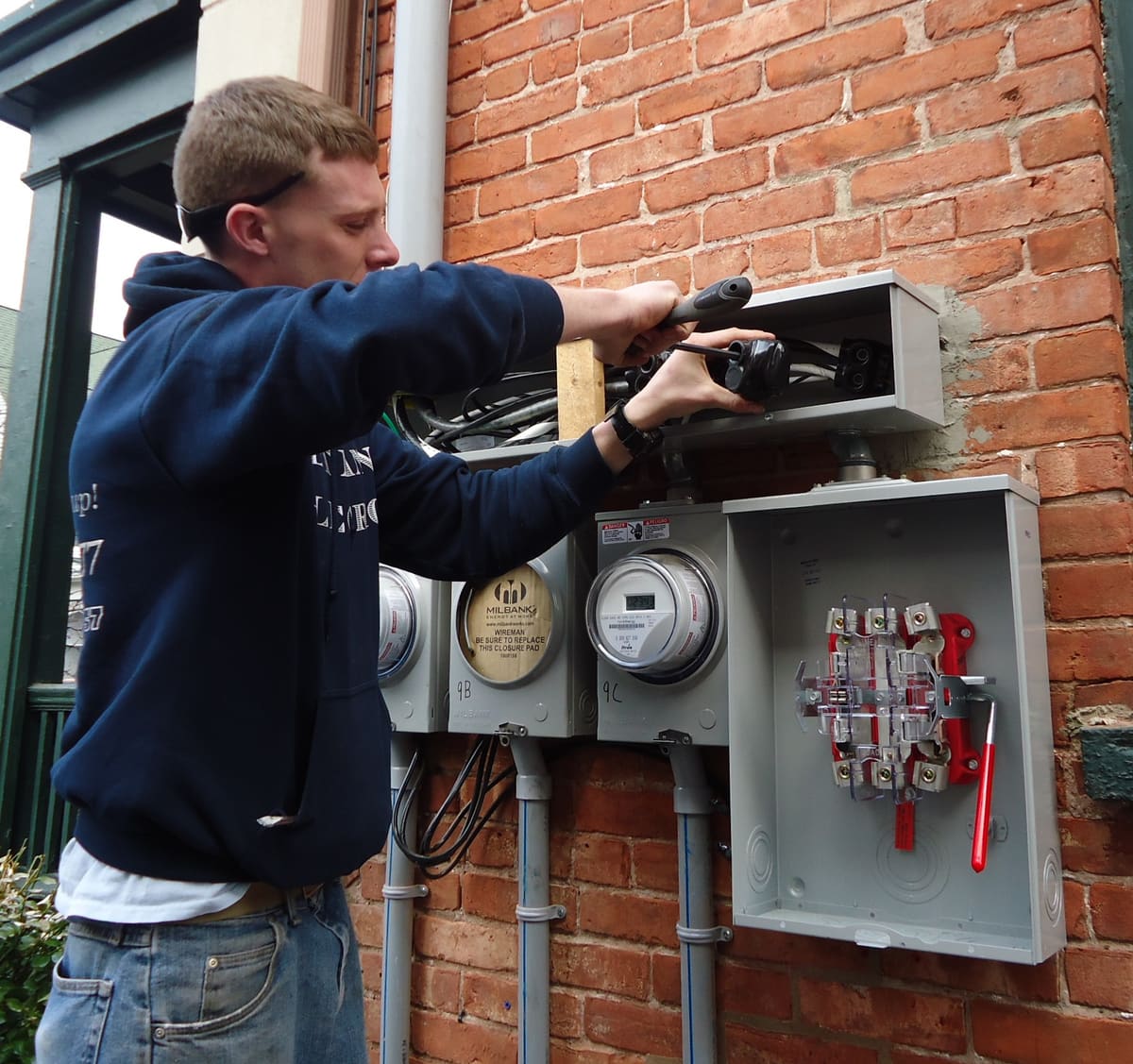 Electrician working on a residential electrical panel and meter base